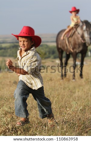 two happy children riding horse on natural background