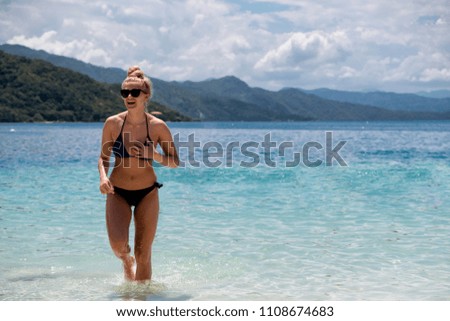 Young woman running to shore on a tropical beach
