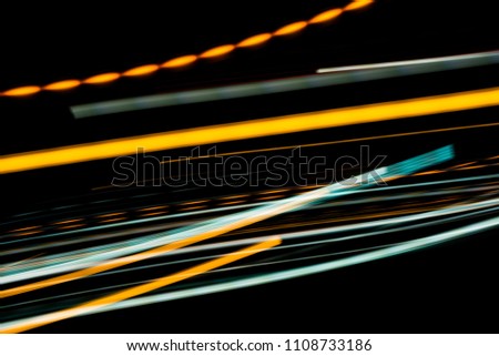Orange and bluel backdrop from fast moving glow particles.stripes and Lights   moving fast over dark background. 