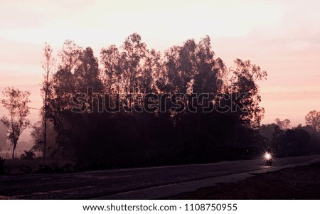 A biker is biking on an empty road in an early morning isolated unique photo