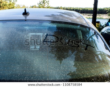 Dirty car with "dust" written on the wind screen