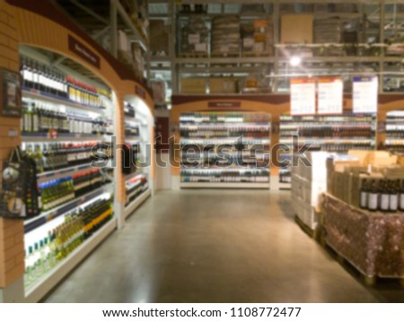 Blurred image of wine shelves display in supermarket. Defocused Rows of Wine Liquor bottles on the store shelf. Alcoholic beverage abstract background. Alcohol drink market concept. Royalty-Free Stock Photo #1108772477