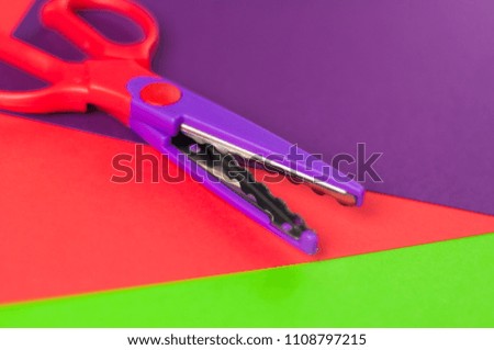 Scissors for figured cutting on blank colored papers. Education concept