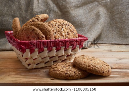 Savory cookies sprinkled with sesame seeds, sunflower on table and burlap background