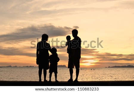 silhouette of family on the beach at dusk.