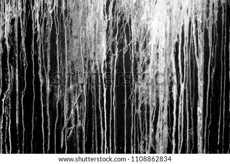 The current white paint on a black background. Brooks of liquid. Vertical flows. Abstract structure. Royalty-Free Stock Photo #1108862834
