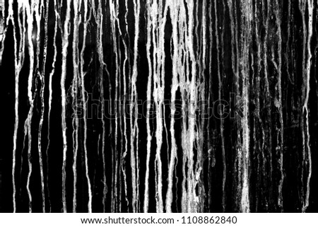 The current white paint on a black background. Brooks of liquid. Vertical flows. Abstract structure. Royalty-Free Stock Photo #1108862840