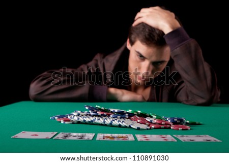 Young handsome man playing texas hold'em poker Royalty-Free Stock Photo #110891030