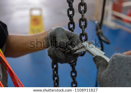 Engineers are inspecting hooks for lifting safety crane steel In the factory auto parts license Crane Operation Royalty-Free Stock Photo #1108911827