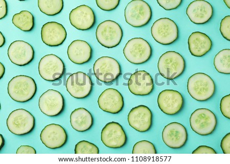 Flat lay composition with slices of cucumber on color background Royalty-Free Stock Photo #1108918577