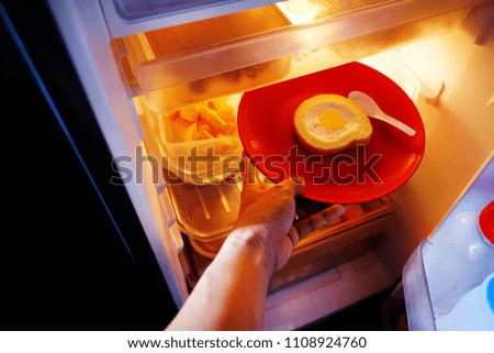 Jam fresh roll on red dish in refrigerator  with orange  light from it.