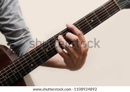 The musicians are catching the guitar chords is A chord full bar on white background,Guitar chords,Selective focus,Guitarist