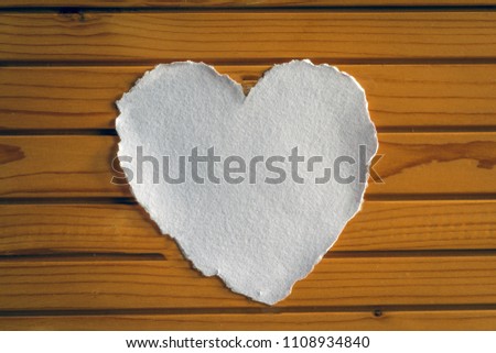 Heart shaped white sheet of paper on a wood panelled background for love notes