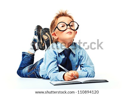 Little boy in spectacles and suit lying on a floor with a diary. Isolated over white background.