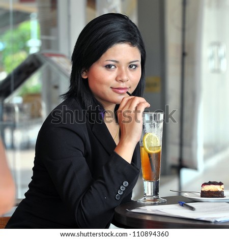 Beautiful young businesswomen drink at cafe