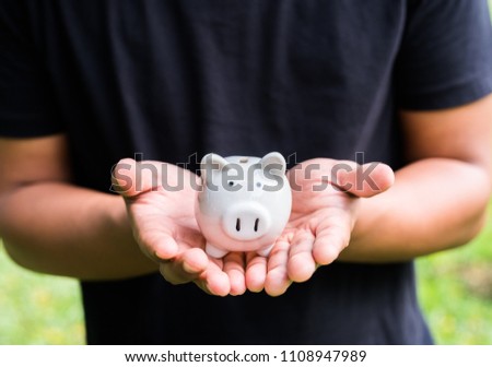 Close up male hands holding piggy bank.