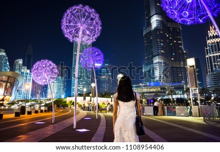 Girl having a walk in downtown Dubai at night Royalty-Free Stock Photo #1108954406