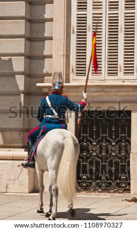Back view of a mounted palace guard with a lance and cavalry uniform in old town, Madrid, Spain on a sunny, summer day Royalty-Free Stock Photo #1108970327