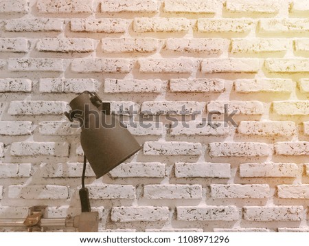 Loft decorating table / wall lamp on fringed white brick wall. Interior design idea.