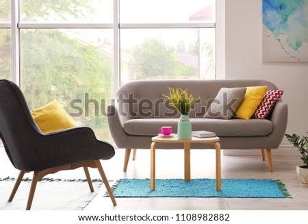Elegant living room interior with comfortable sofa and armchair