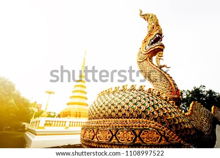 Golden Naga statue in the front door of thai traditional buddhist temple - Phrae, Thailand