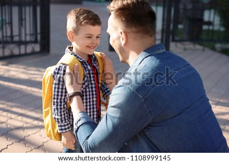 Young man saying goodbye to his little child near school Royalty-Free Stock Photo #1108999145