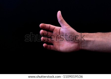 hand holding something on black background 