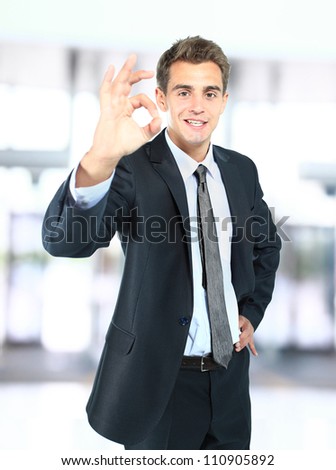 Portrait of smiling business man giving you OK sign in office