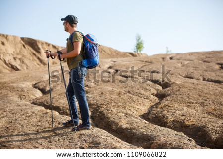 Image of side athlete with backpack and walking sticks