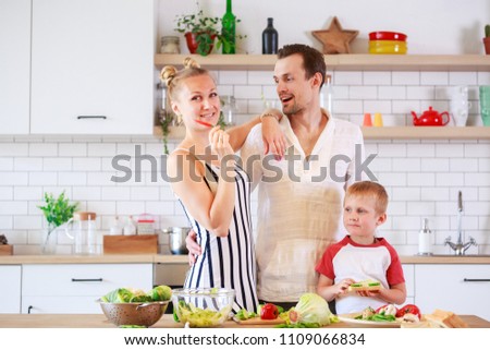 Photo of mother, father and little son preparing food in kitchen