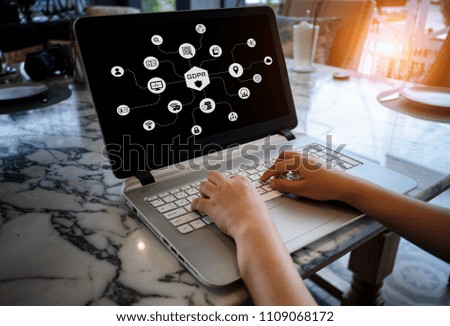 The businessman is professional working with laptop on the table and network diagram of GDPR graphic overlay on the screen of laptop. 