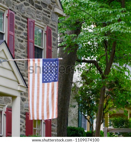 American Flag Hanging From Stone House