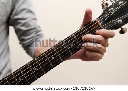 Selective focus,Guitarist,The musician is holding the guitar chords calling D  seven chord on white background