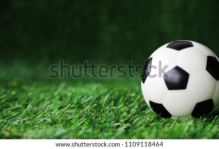 front View Football ball on green grass Copy space