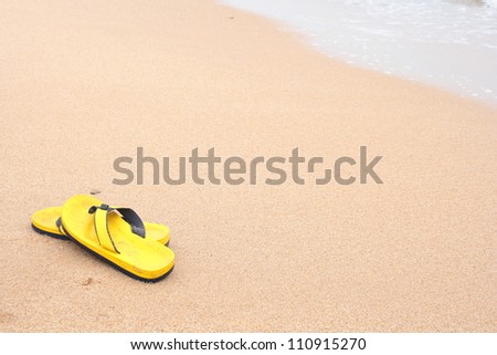 Yellow beach slippers on sandy beach, summer, bathing