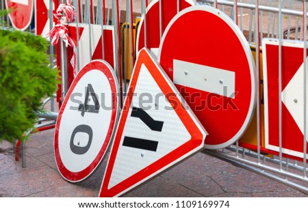Street of the city. On the heap lie road signs: stop, narrowing the road. Horizontal frame. Color image. Photographed in Ukraine, Kiev region