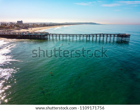 Aerial photo of a very long pier with houses and cars in San Diego California
