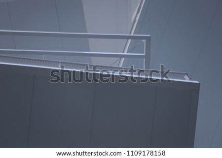 Close up outdoor view of pattern of white rectangular balconies seen from bellow. Abstract urban image with polygone shapes, angles and lines. Modern architecture with ceilings and exterior barriers. 