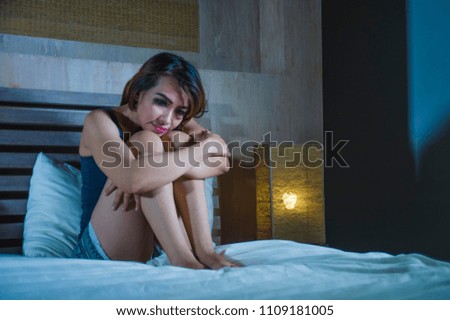 young sad and depressed Latin woman sitting on bed thoughtful and worried about problem or feeling sick and unwell in stress and depression broken hearted feeling frustrated in pain