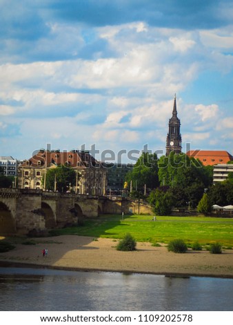 Bright streets of Dresden, buildings and green trees on the background of the blue sky