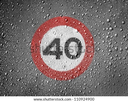 Speed limit sign painted on metal surface covered with rain drops