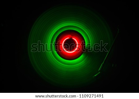 Music concept. Freezelight glowing vinyl on dark background or Turntable playing vinyl with glowing abstract lines concept on dark background. For Club poster Design