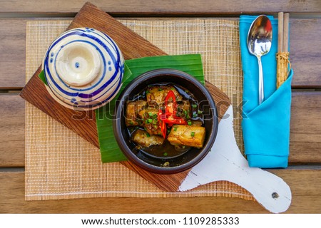Ca kho to (Braised fish cat) Vietnamese cuisine. In a ceramic cooking pot, catfish is deeply cooked in fish sauce, pepper topping & eaten along with plain/brown rice, more perfect with vegetable.