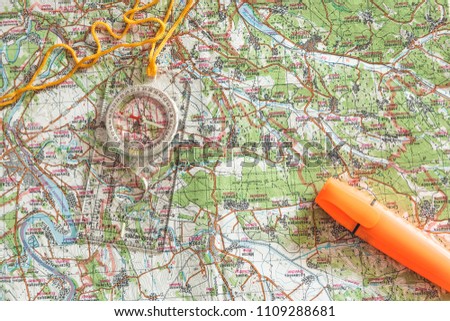 A compass and an orange marker on a map