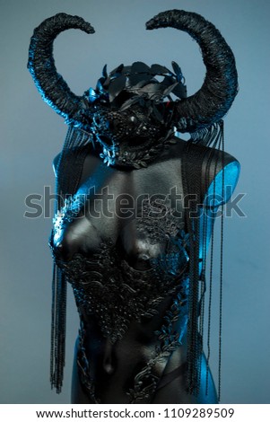 Ritual Witch. Black dress with helmet of big dark horns. pieces of metal and corset of rhinestones and lace