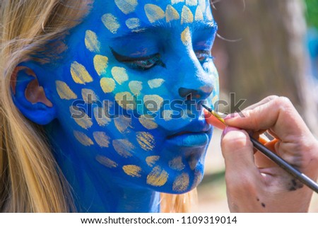 process of drawing on the face, body art blue dragon