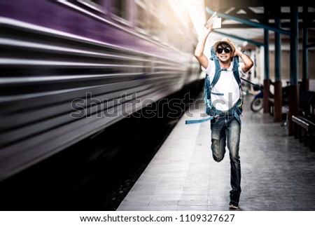 Traveler man running after a moving train from a railway station Royalty-Free Stock Photo #1109327627