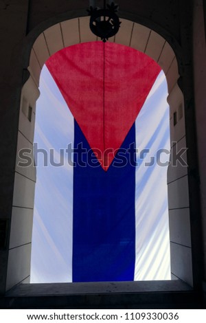 National flag of Cuba hanging in window - Havana, Cuba