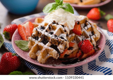 Waffles with berries, strawberries, chocolate on top and mint
