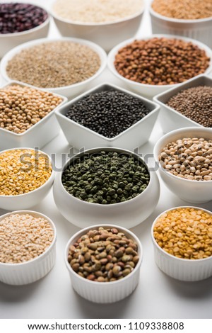 Uncooked pulses,grains and seeds in White bowls over white background. selective focus
